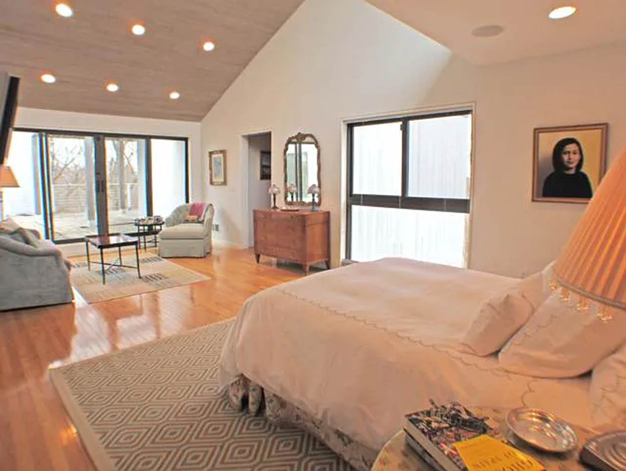 A bedroom with a large bed and a large glass door
