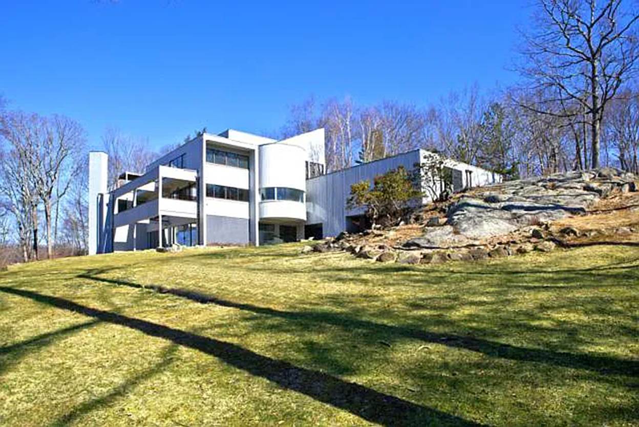 A large white building with trees in the background
