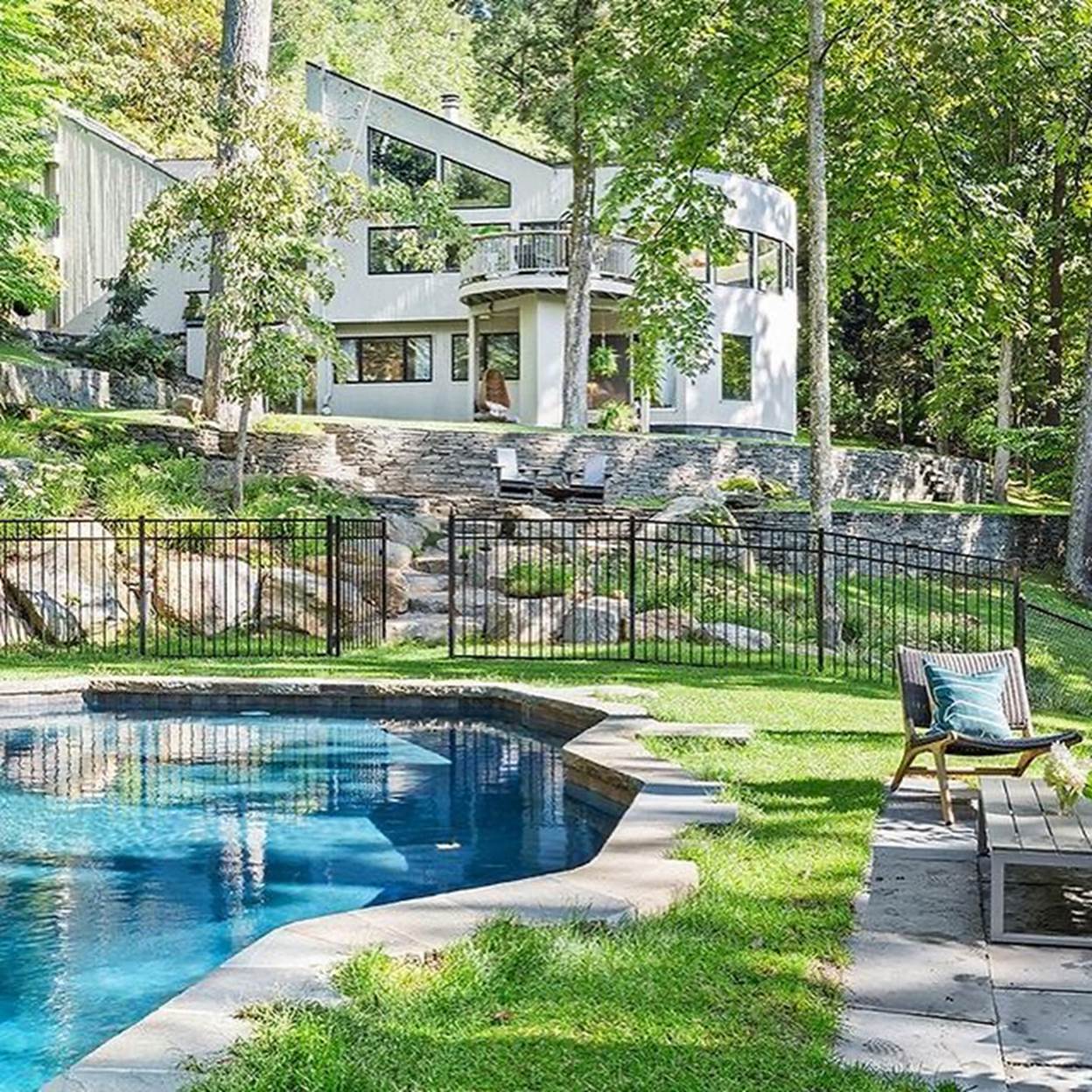 A pool in a backyard with a house in the background
