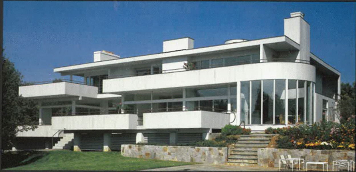 A white building with a stone wall
 with medium confidence