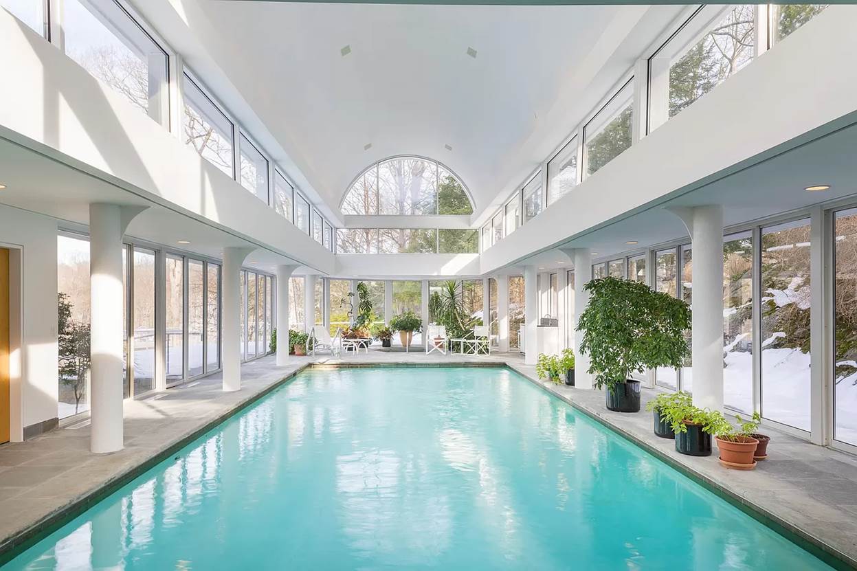 A indoor swimming pool with a large glass ceiling
 with medium confidence